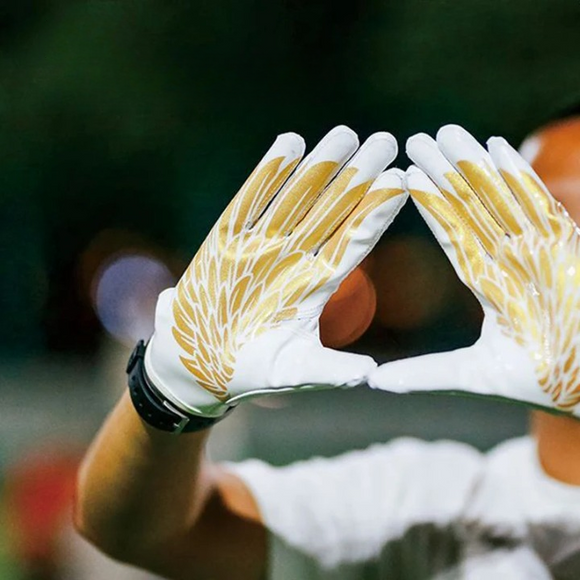 Gant football américain blanc avec imprimé ailes dorées sur les mains d'un homme