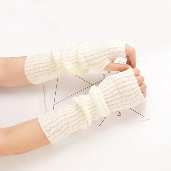 Gants sans doigts montants pour femme portés par une femme avec une feuille en dessous de ces mains sur fond blanc